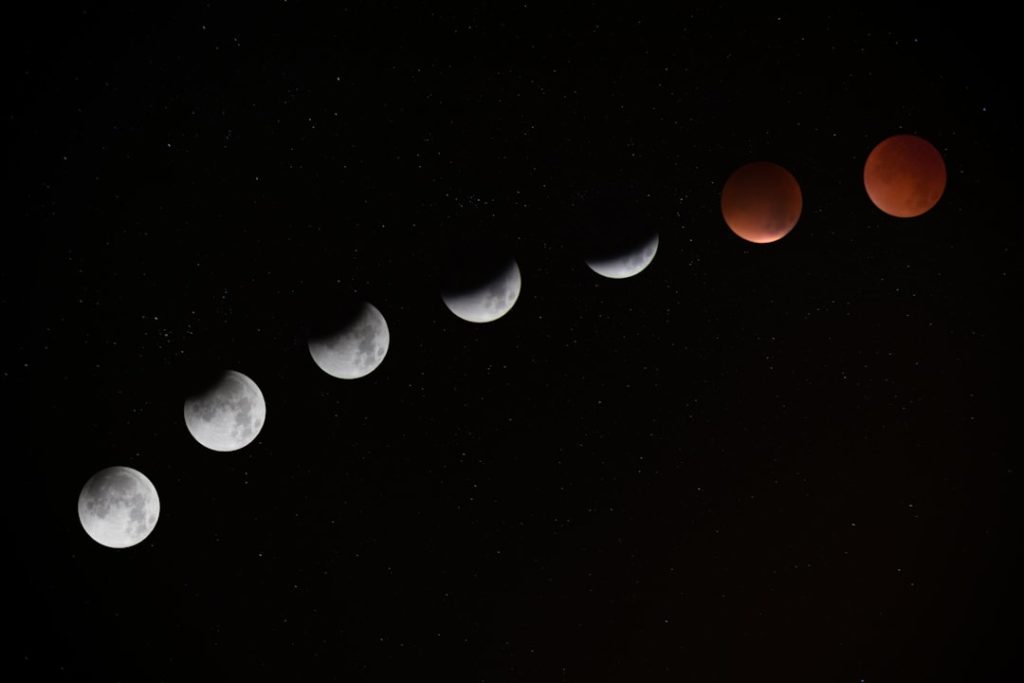 A deep red Blood Moon glowing against a dark night sky during a total lunar eclipse